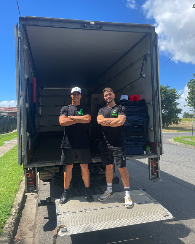 A PicUp driver and offsider standing on the tail-lift of a loaded removals truck